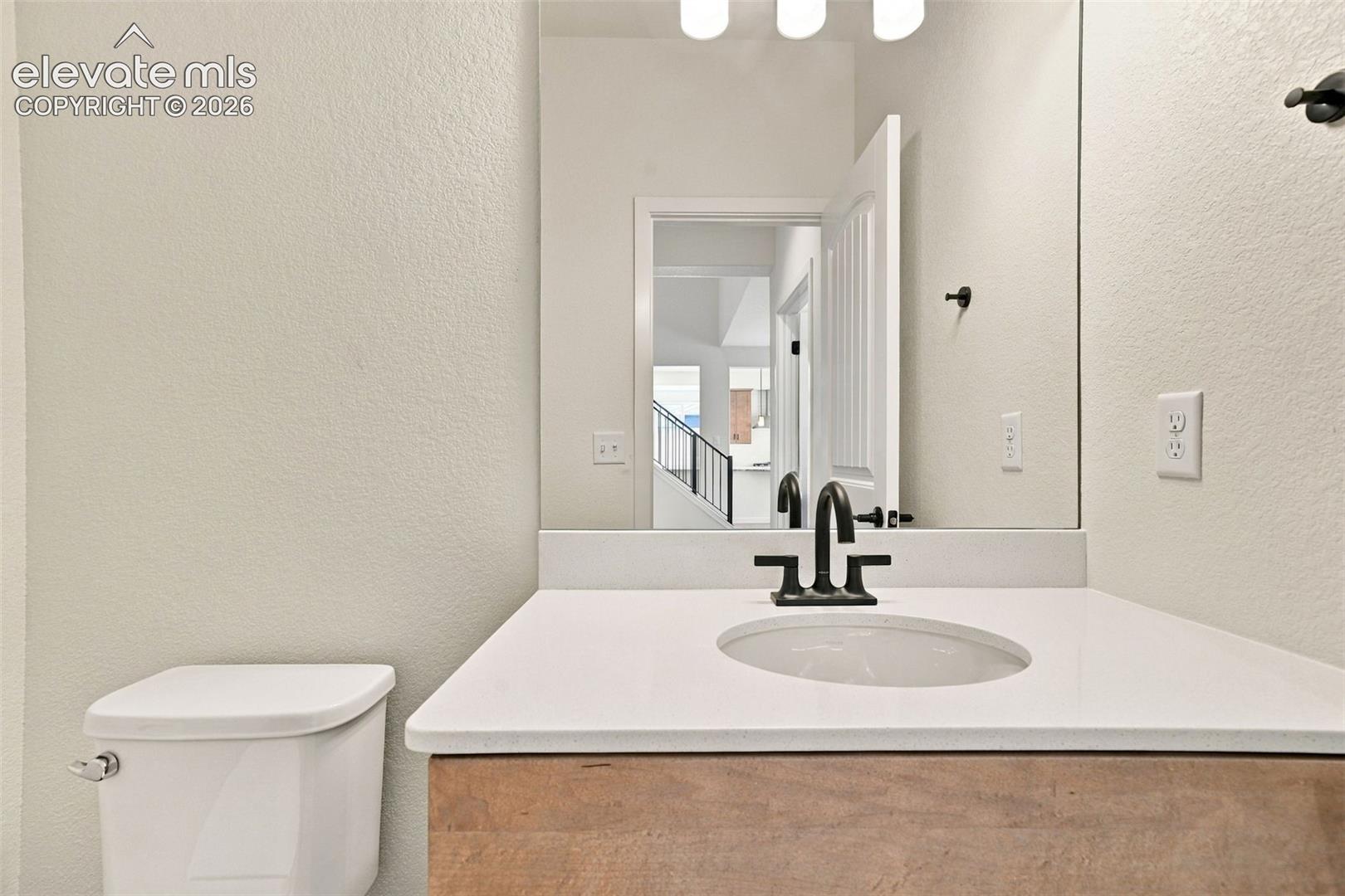 Vanity with an undermount sink, quartz countertop, and maple cabinets with pecan stain.