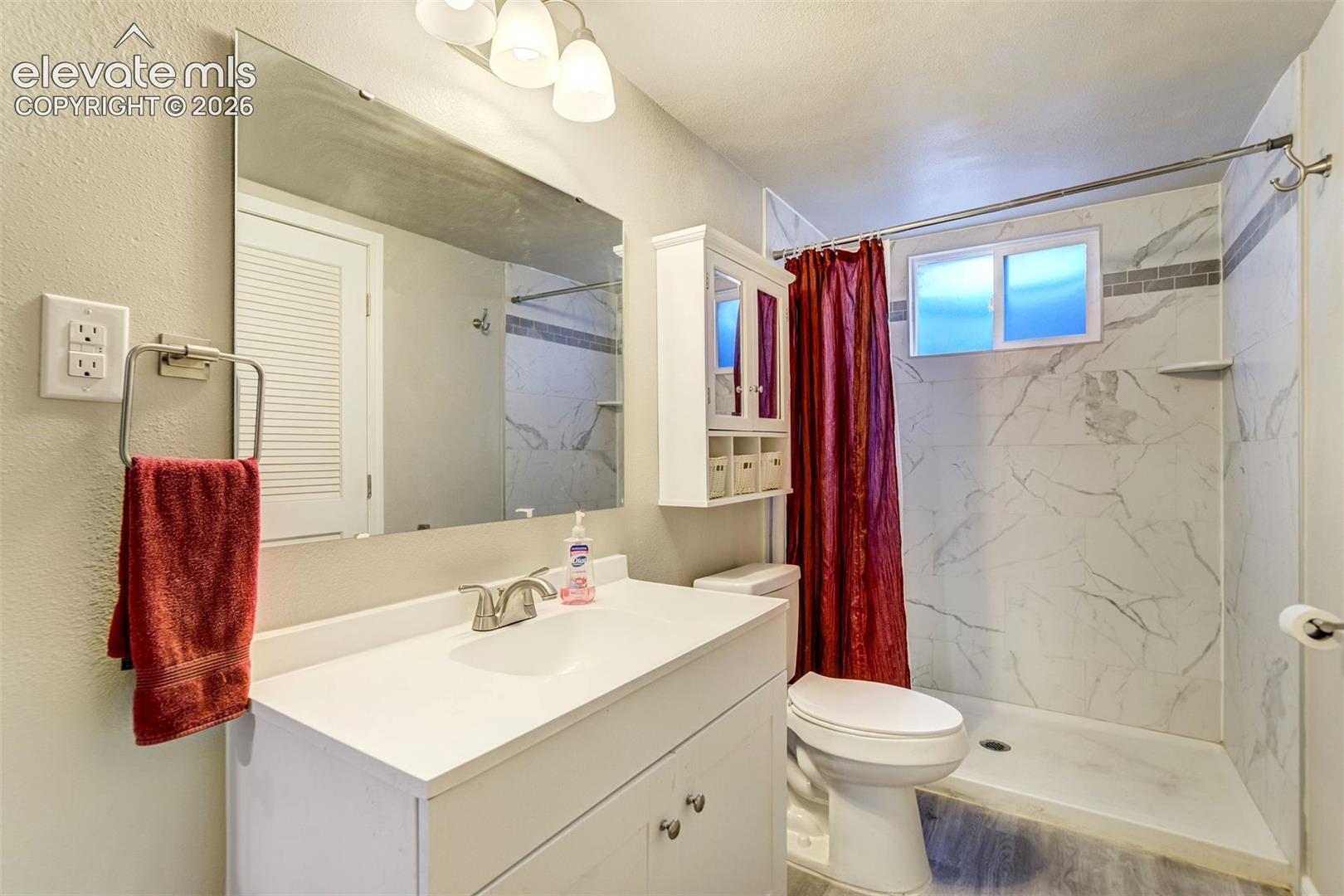Beautifully updated basement bath, leads to laundry/utility room.