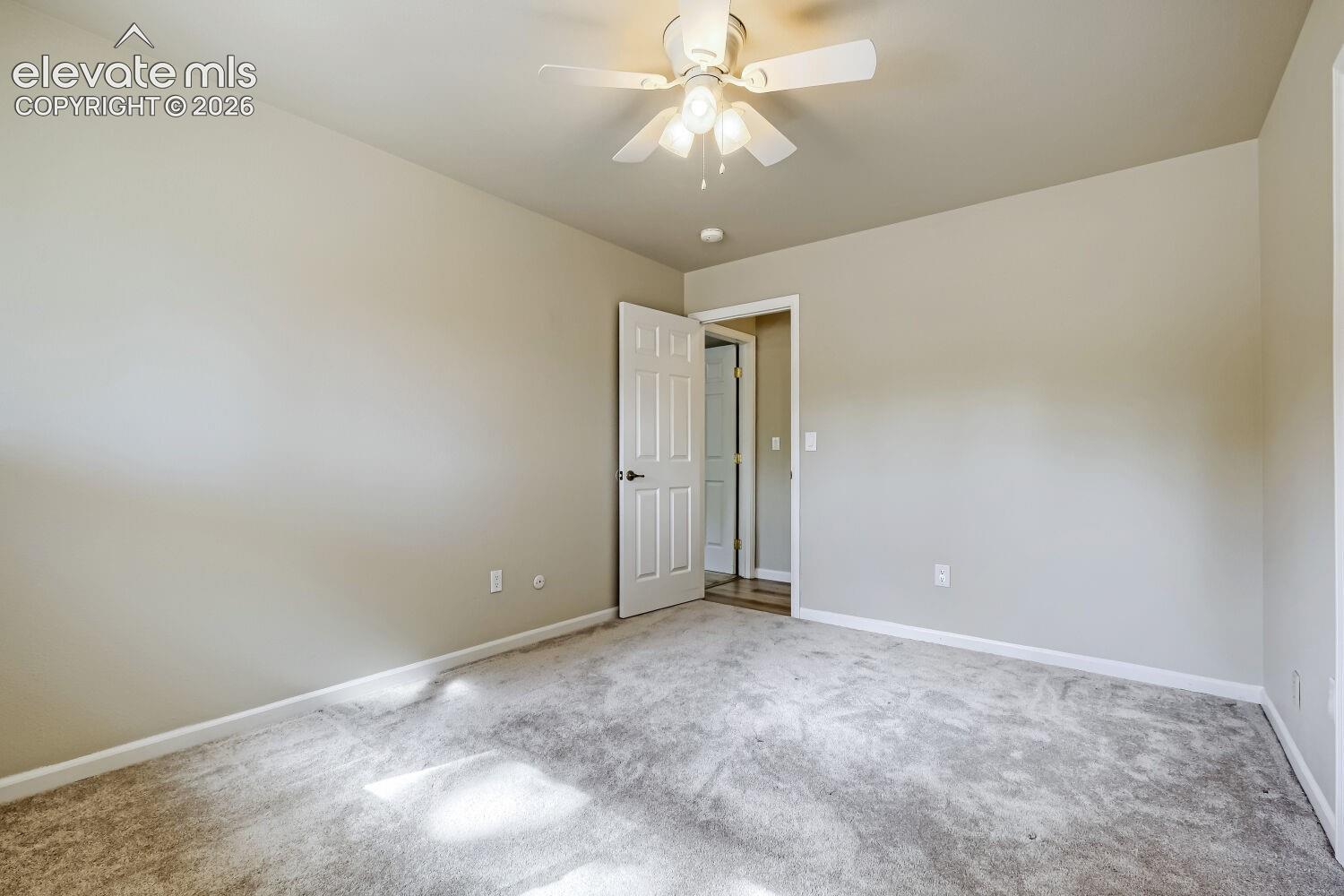 Neutral tone walls, ceiling fan with integrated lighting, textured carpeting, and white trim