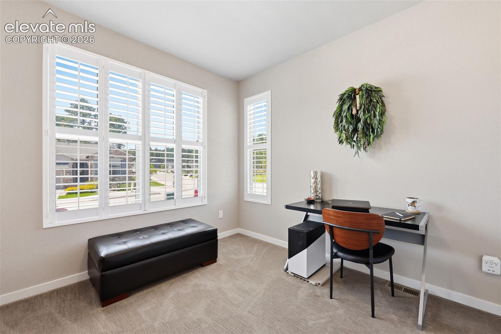 Neutral wall tones, plantation shutters, recessed lighting, and carpet flooring.