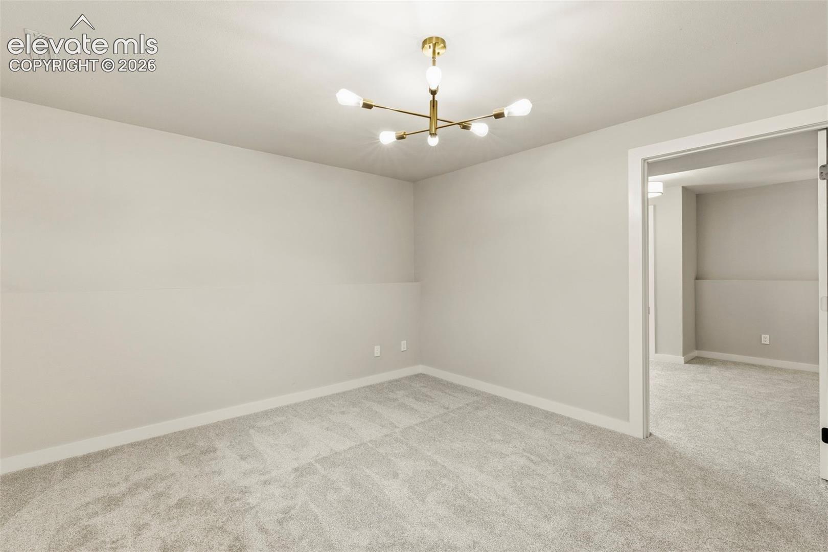 Spacious room featuring light gray walls, new taupe carpeting, and white trim