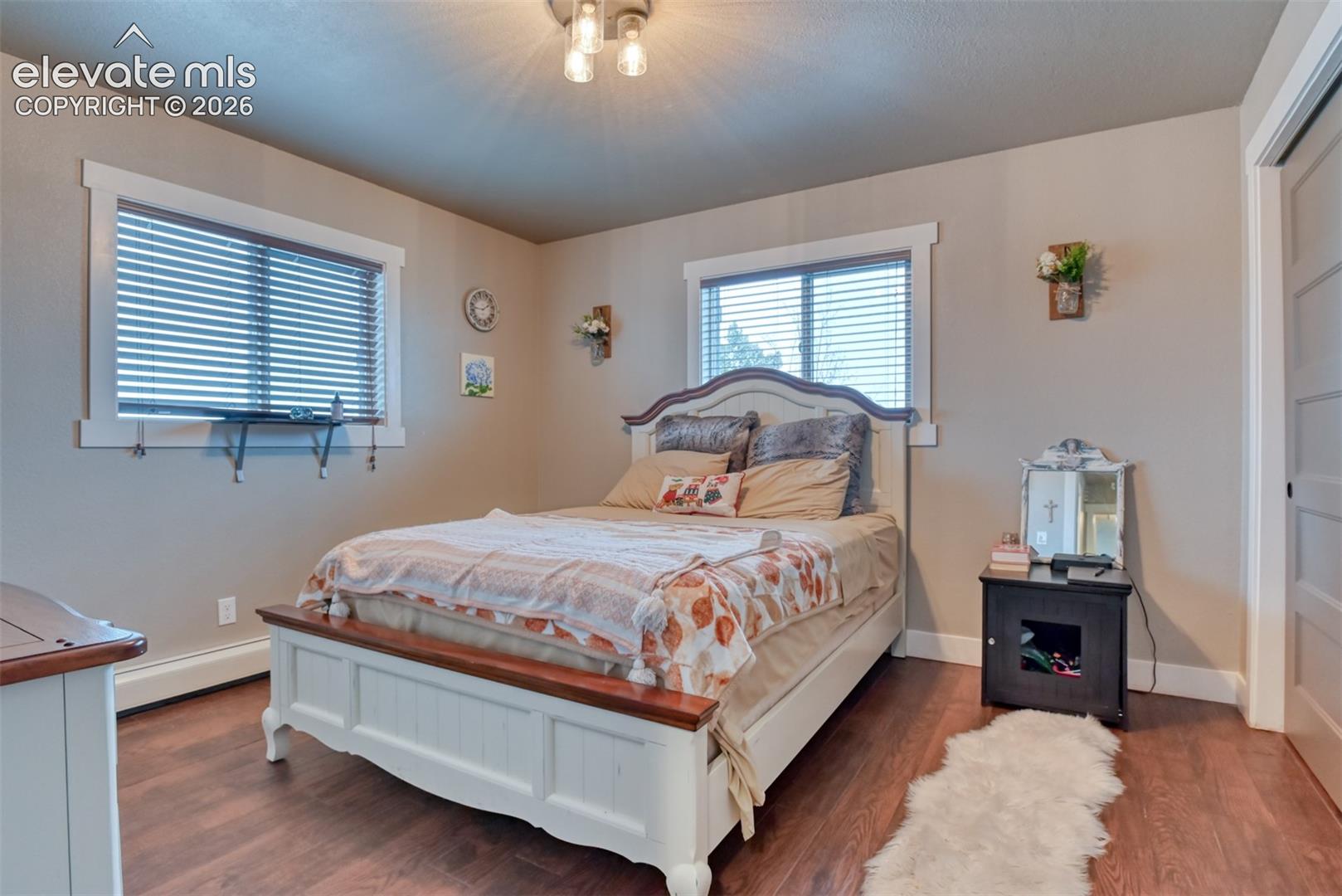 Bedroom featuring wood finished floors and baseboard heating