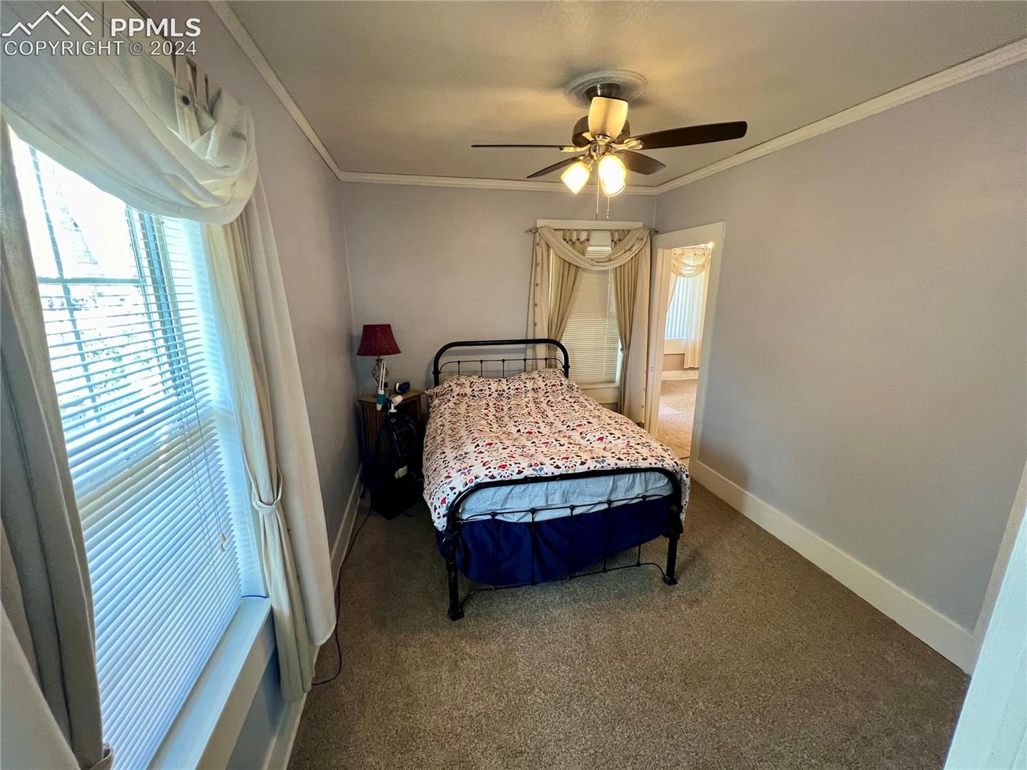 Bedroom featuring ornamental molding, ceiling fan, and carpet floors