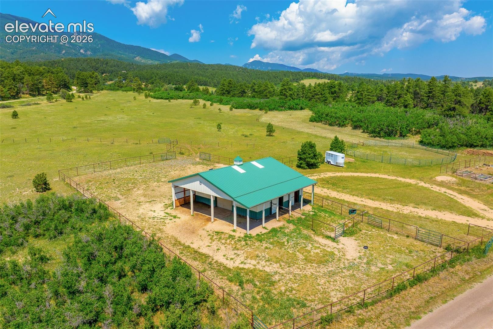View of stable and pasture photographed June 2026
