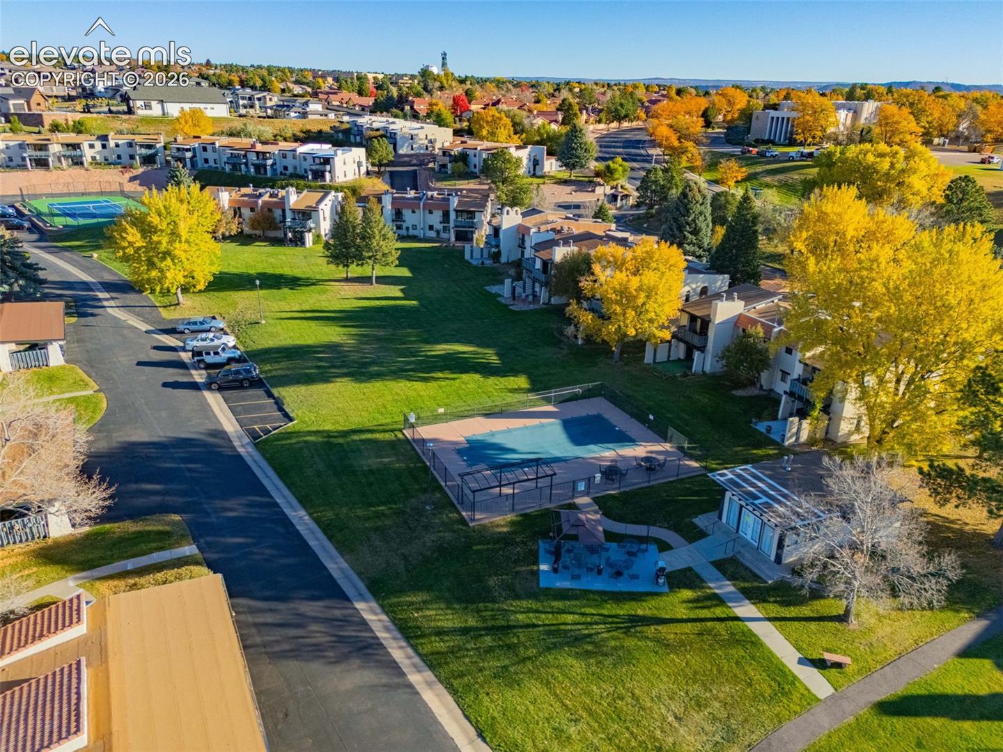 Community green space featuring a swimming pool, tennis court, and playground area