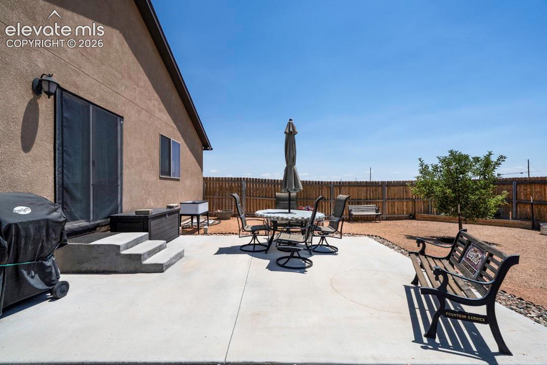 Expansive concrete patio offering direct access to the interior via a sliding glass door