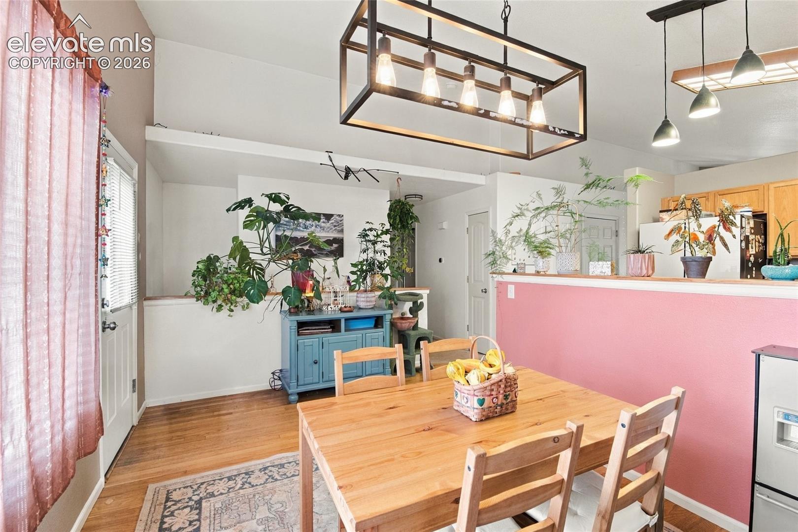 Dedicated dining space w/ updated lighting, a large window, & walkout to deck