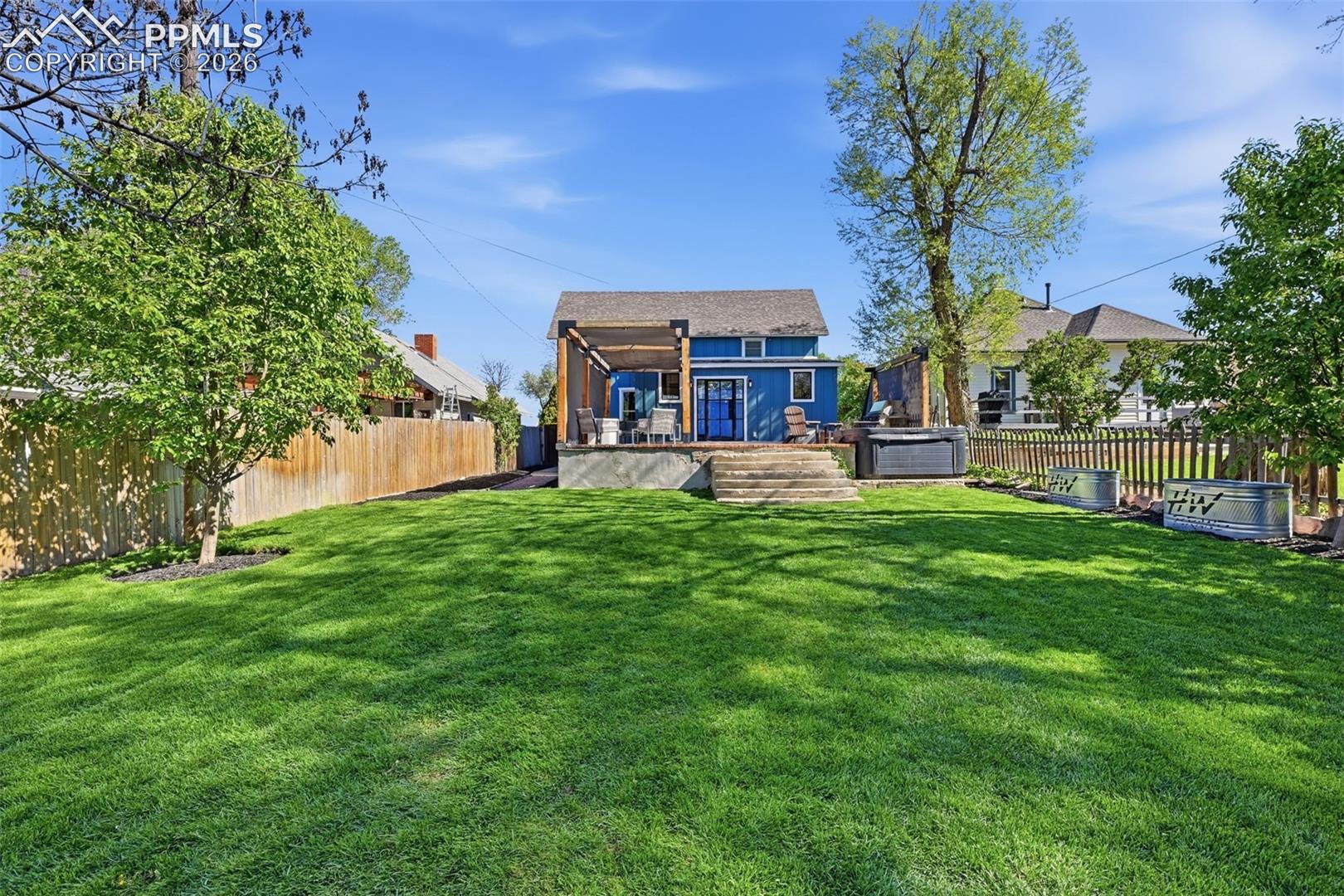 This property has drought-tolerant landscaping in the front, and lush green lawn in the back with multiple raised garden beds.