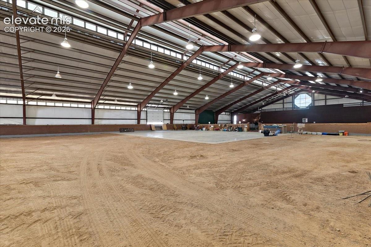 Dirt arena area looking toward the tennis court and loft area. There are 40 Halogen overhead lights.