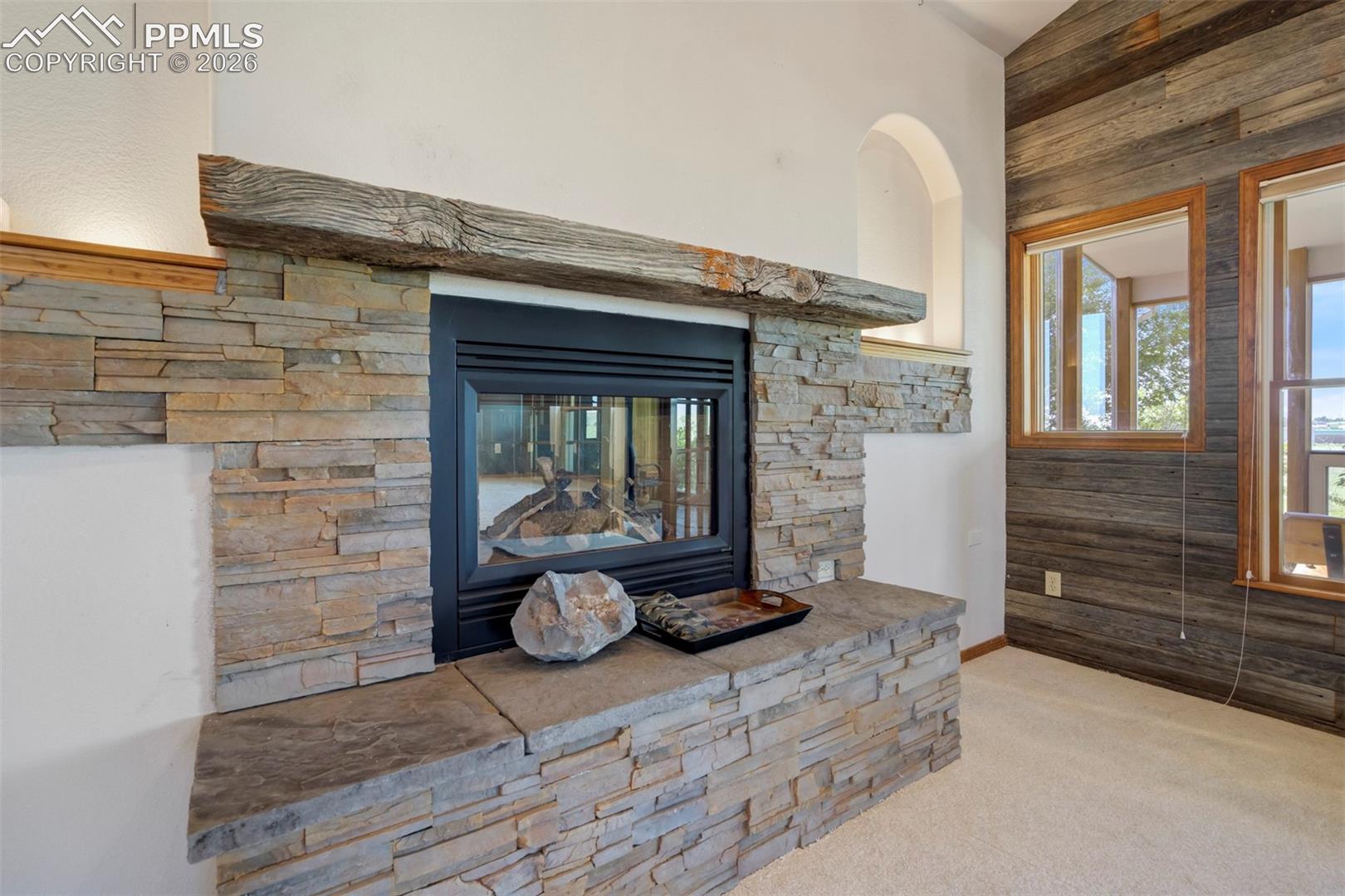 Stone-clad fireplace with a substantial timber mantel