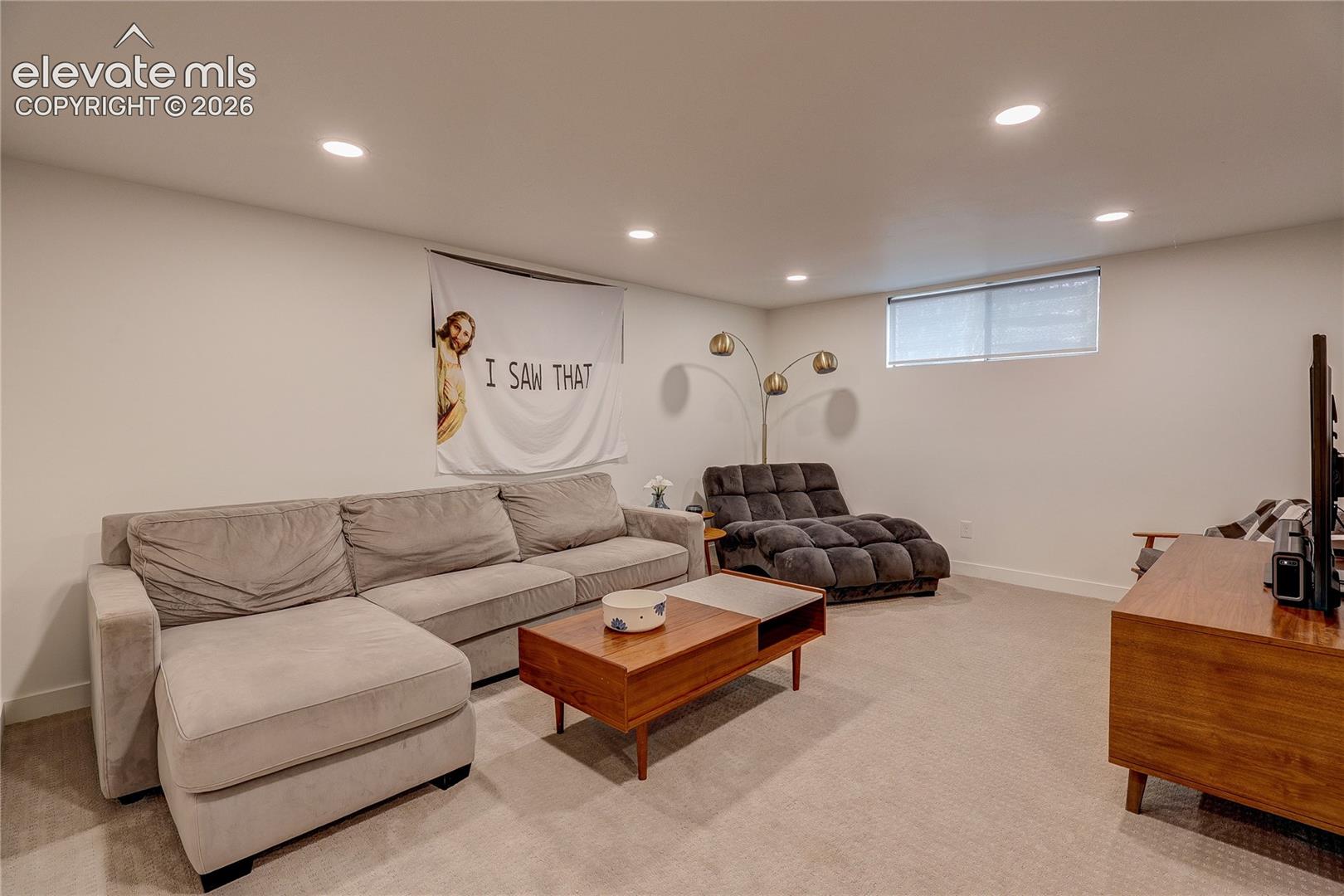 Recessed lighting throughout, neutral-toned walls, and carpet flooring