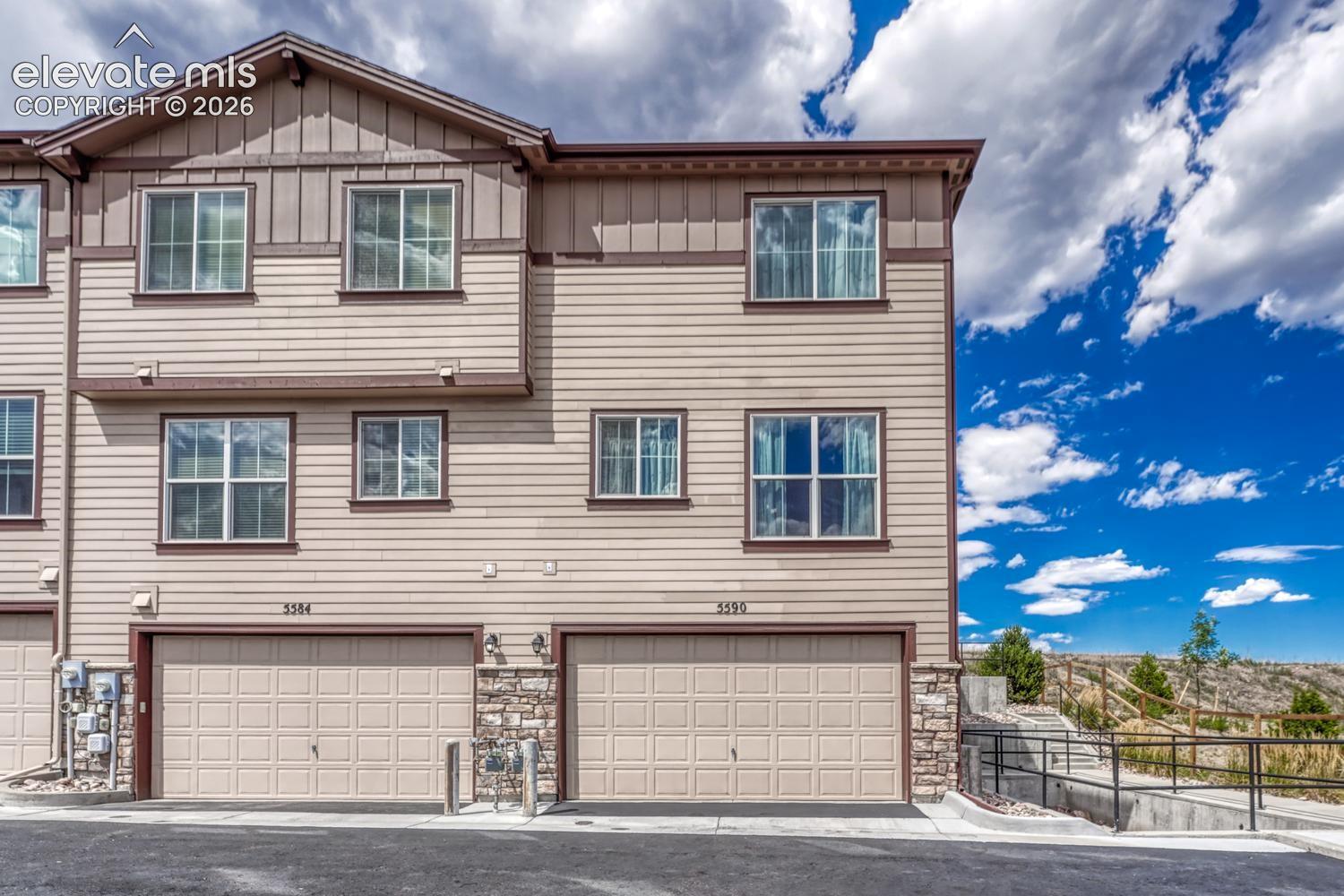 Rear view of townhome with 2-car attached tandem garage.