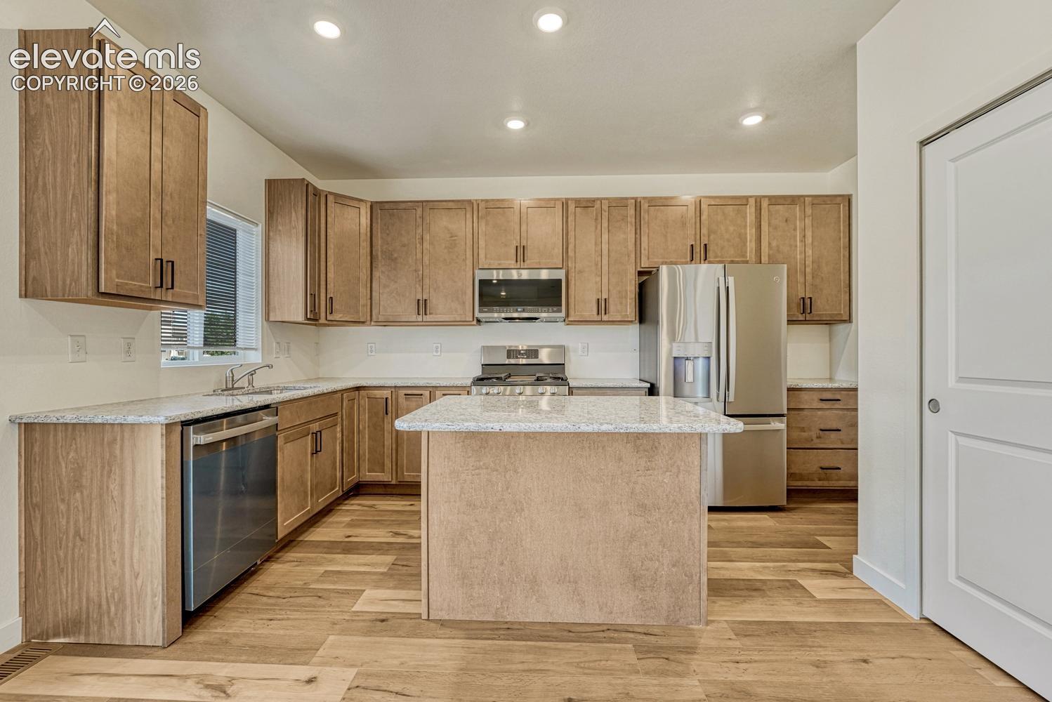 Kitchen features granite counters, bar-top island, and 42in extended height upper cabinetry