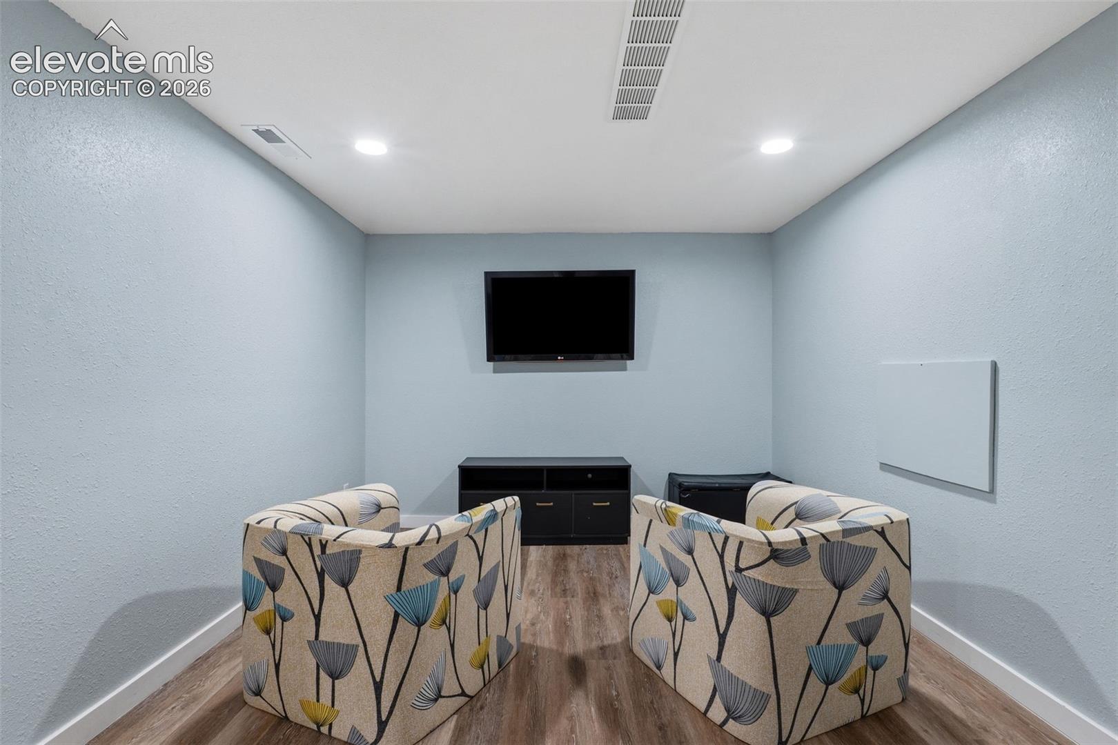 Recessed ceiling lighting, wood-finish flooring, and light blue wall finish