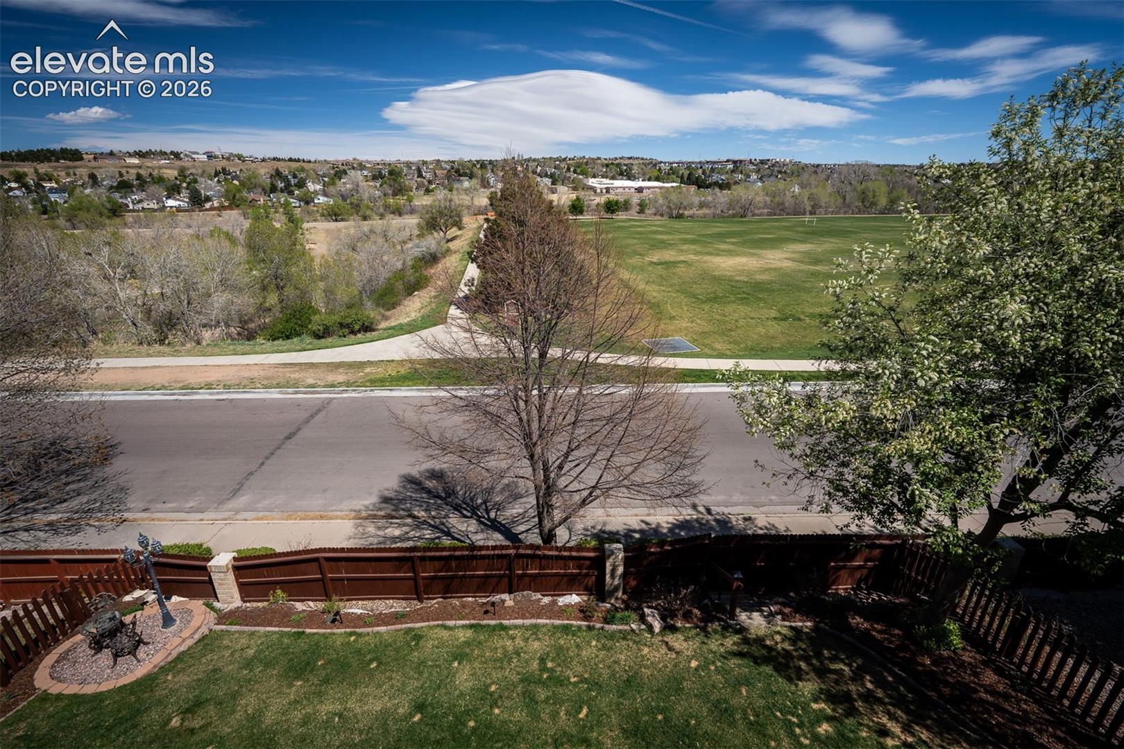 Expansive green space and distant residential areas under a clear sky from the upper deck.