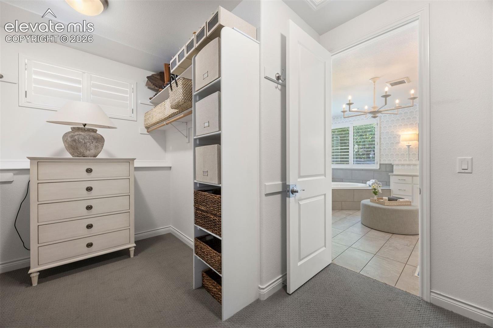 Carpeted room with a full-view door opening into a tiled bathroom