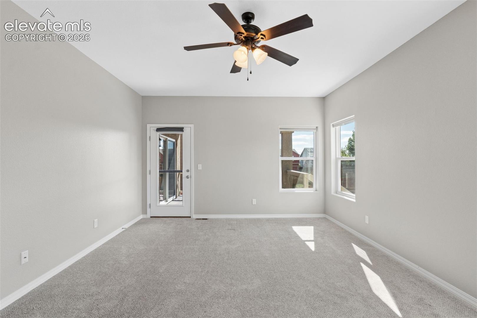 Spacious room featuring light gray carpeting and neutral wall tones