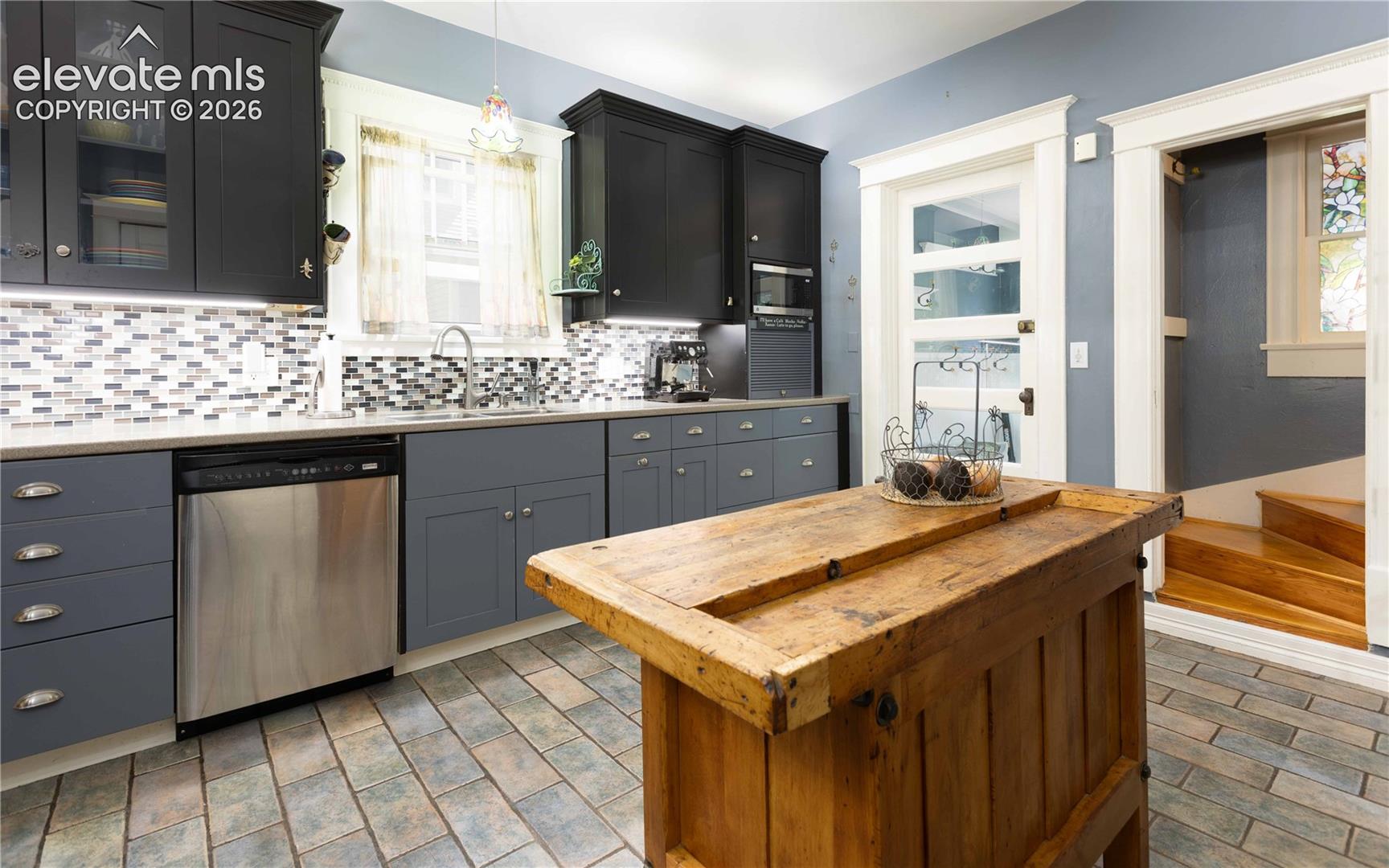 Wide open kitchen with access to back laundry and second staircase