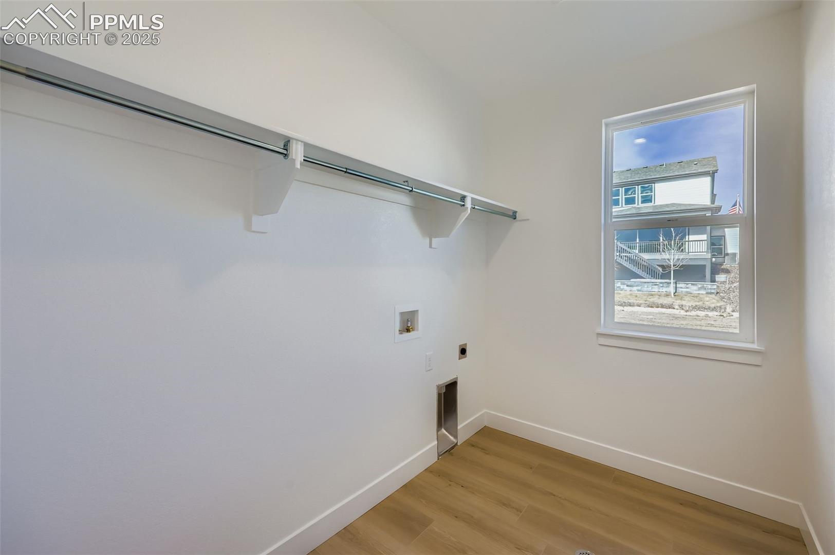Laundry room featuring light wood finished floors, electric dryer hookup, and washer hookup