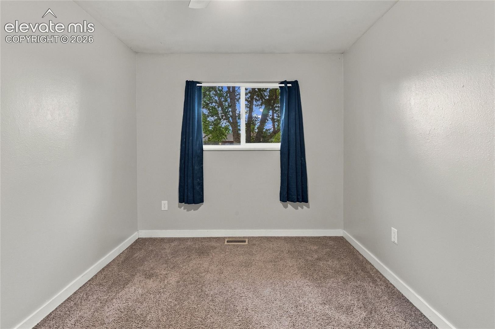 Main level secondary bedroom or home office with a ceiling fan with integrated lighting