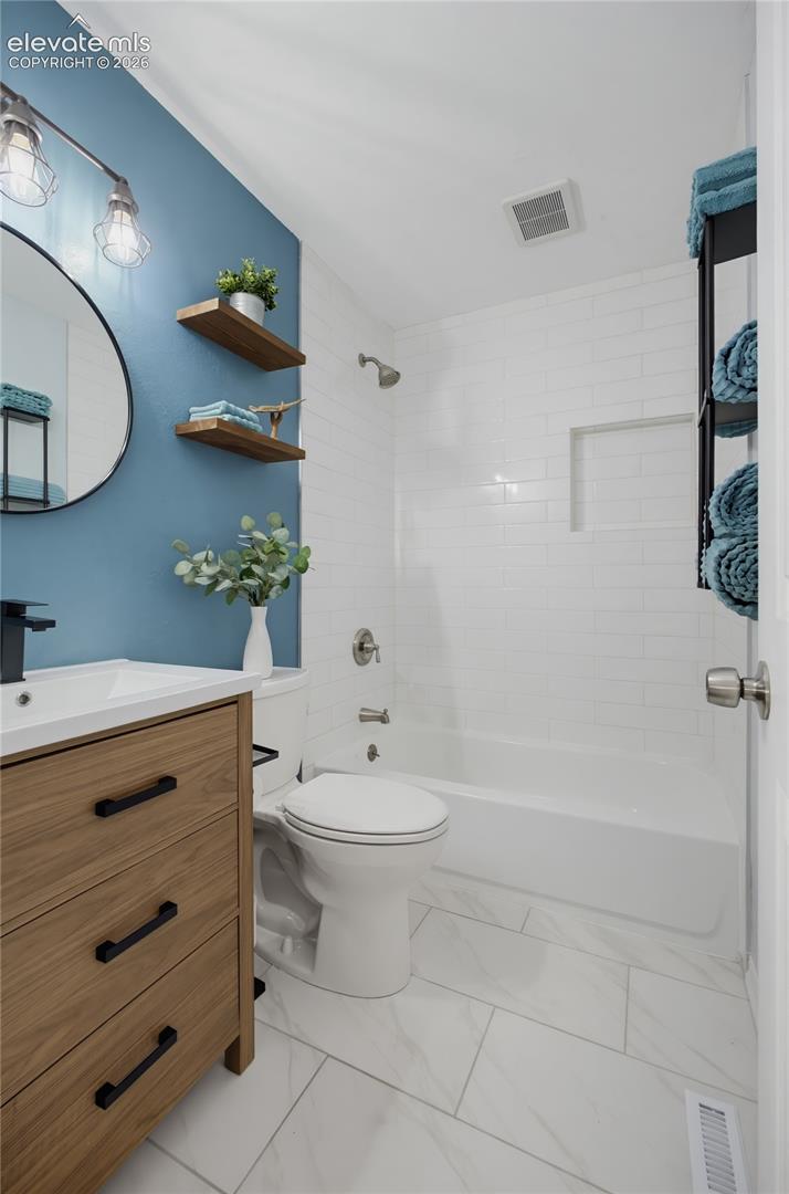Wood-finish vanity with black hardware, white rectangular sink, and matte black faucet