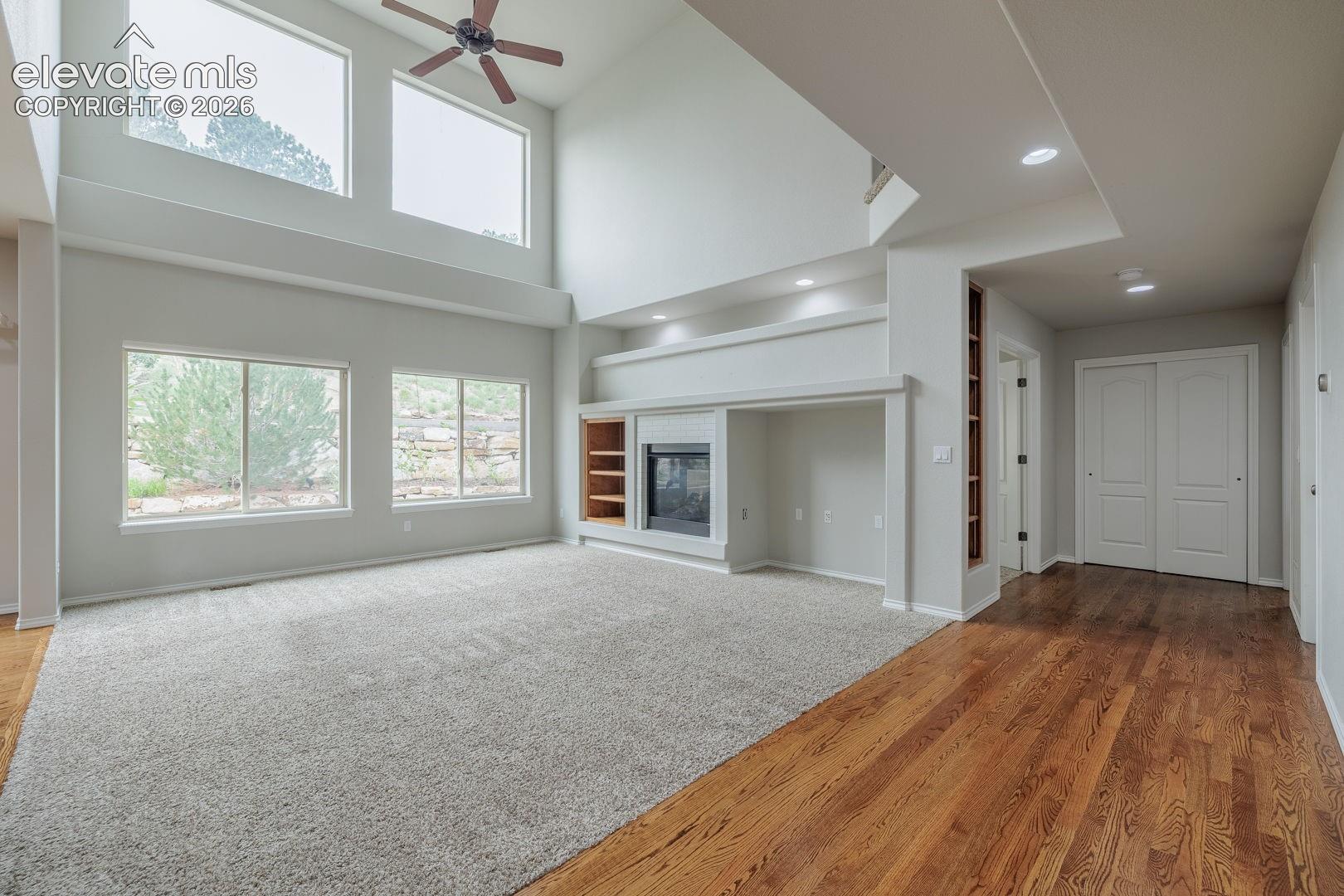Spacious open-concept living area featuring vaulted ceilings with skylights, recessed lighting, and ceiling fan