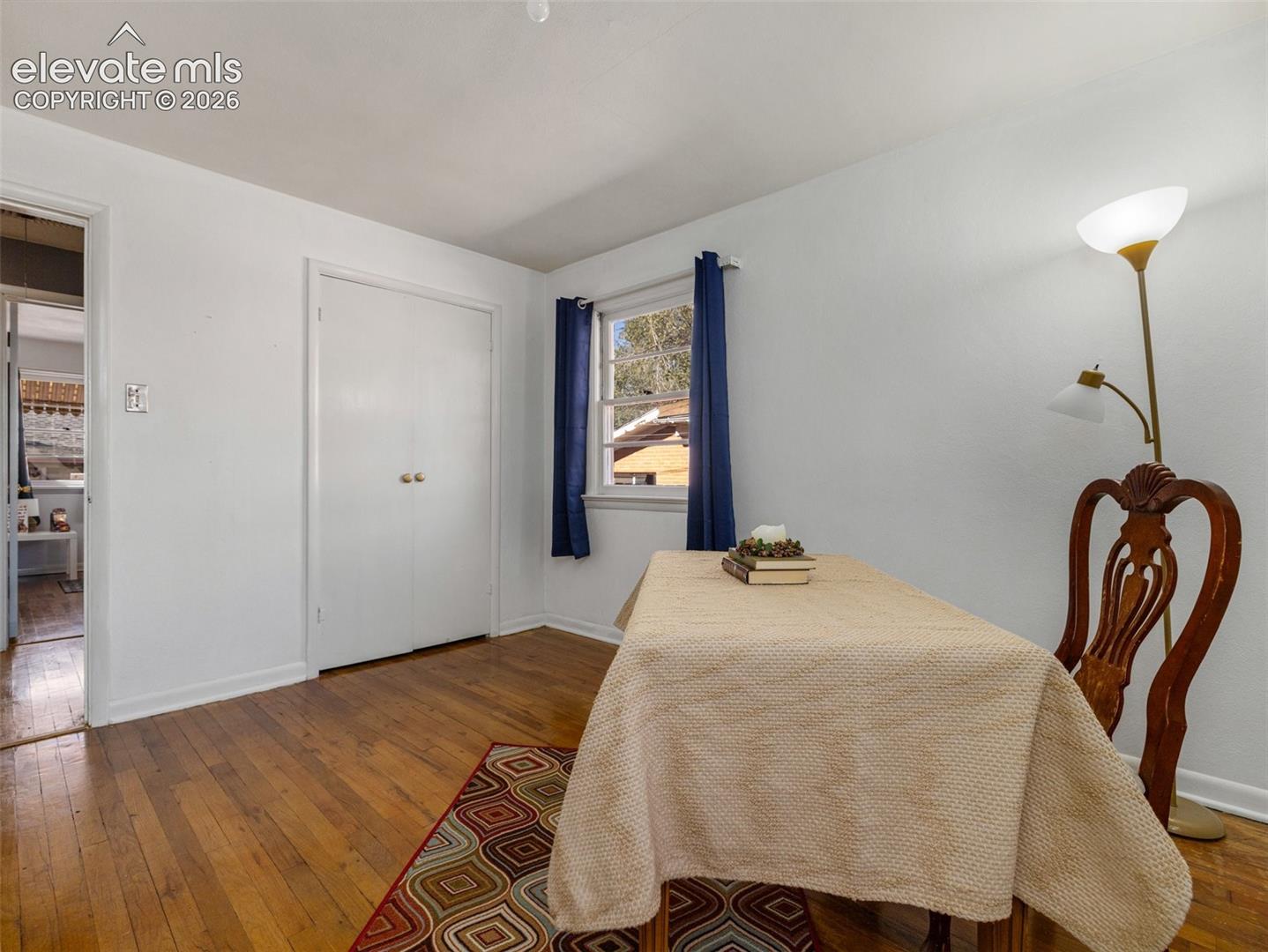 Interior space featuring wood-finish flooring, white walls, and a double-door closet