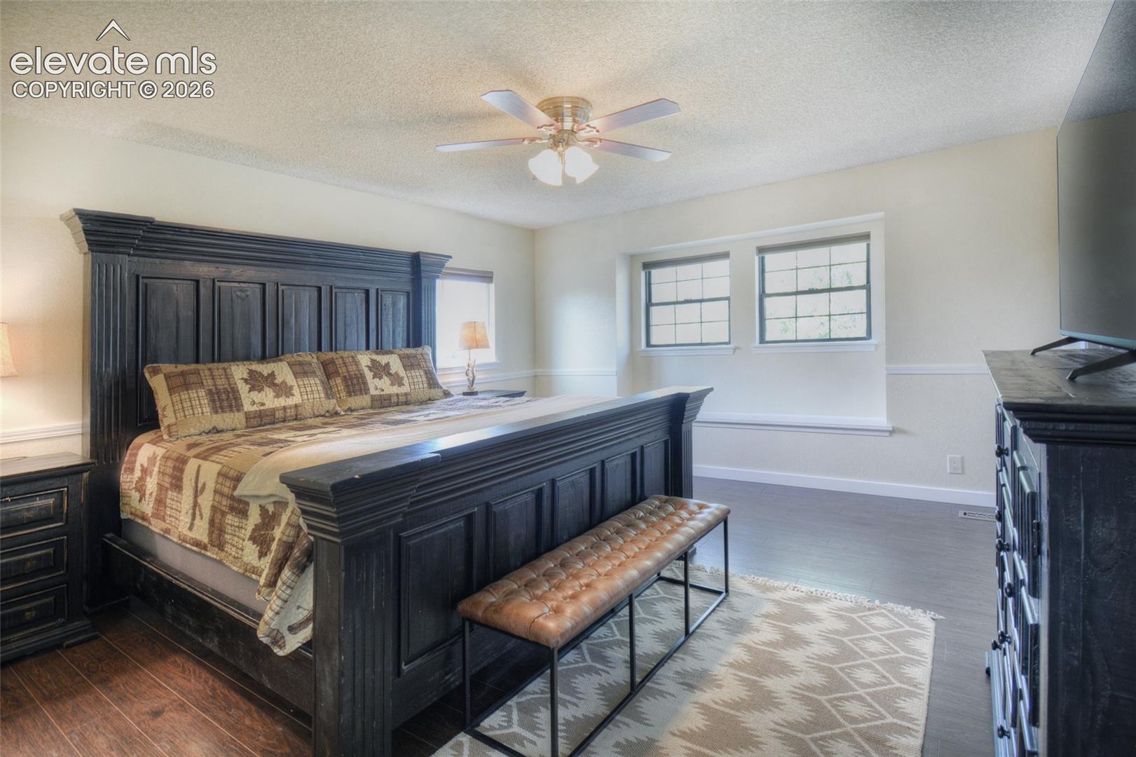 Spacious primary bedroom, LVP flooring, window bench, and adjoining private primary bathroom.