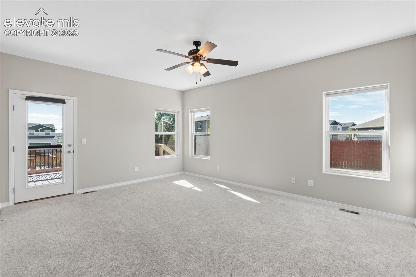 Spacious interior room featuring light gray walls and plush gray carpeting