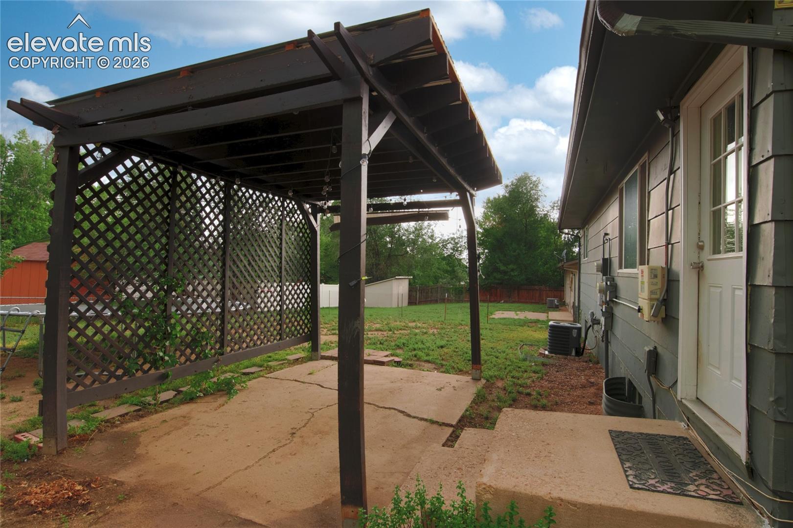 Backdoor into pergola and large backyard