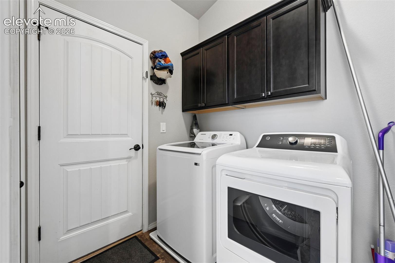 Laundry area featuring dark wood-finish cabinetry and laundry appliance connections