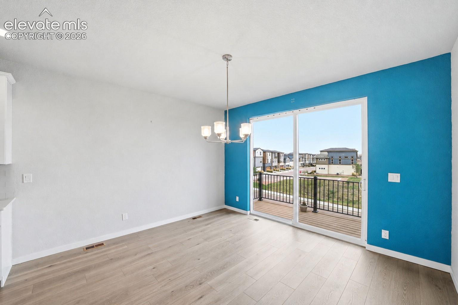 Sliding glass door, wood-finish flooring, recessed ceiling lighting, contemporary chandelier, deck with black railings