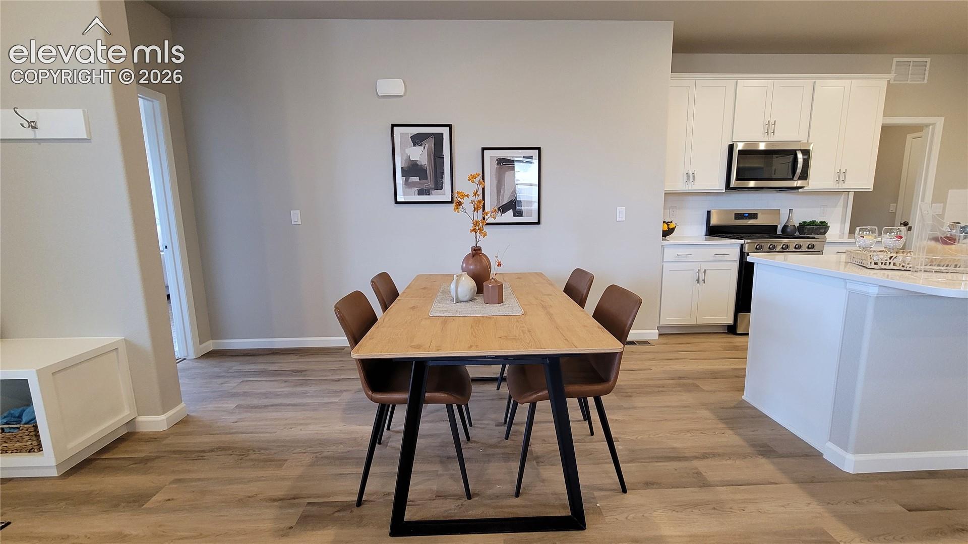 Dining area with LVP flooring, LED light, ready to host a dinner party! 