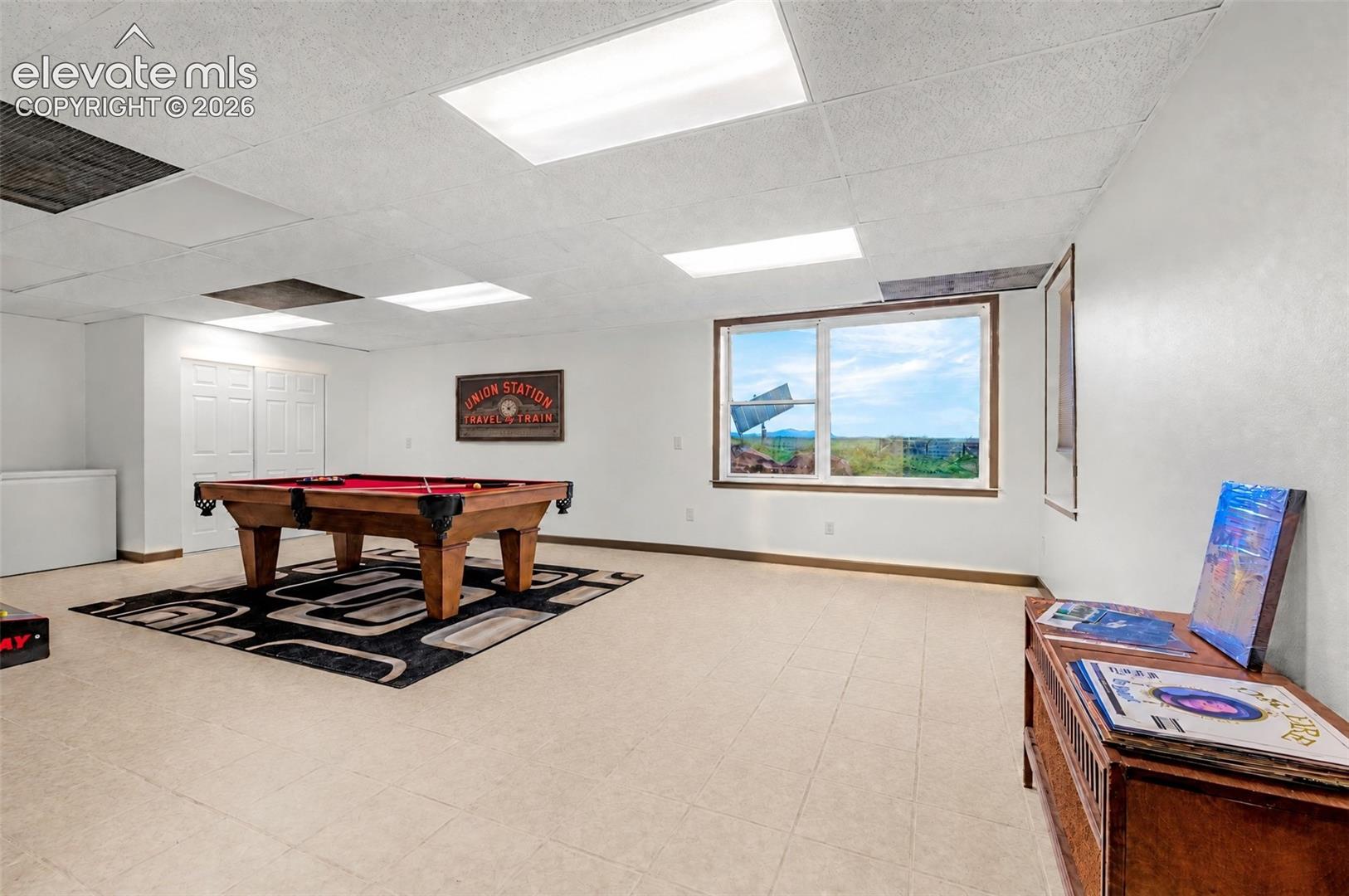 Recessed lighting, light-toned flooring, and expansive windows with wood-finish trim