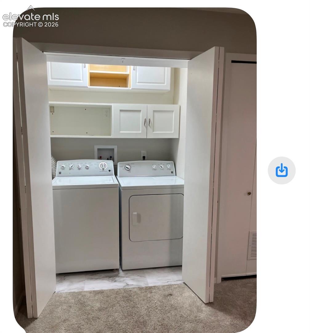 Dedicated laundry area with built-in cabinetry, shelving, and a washer and dryer