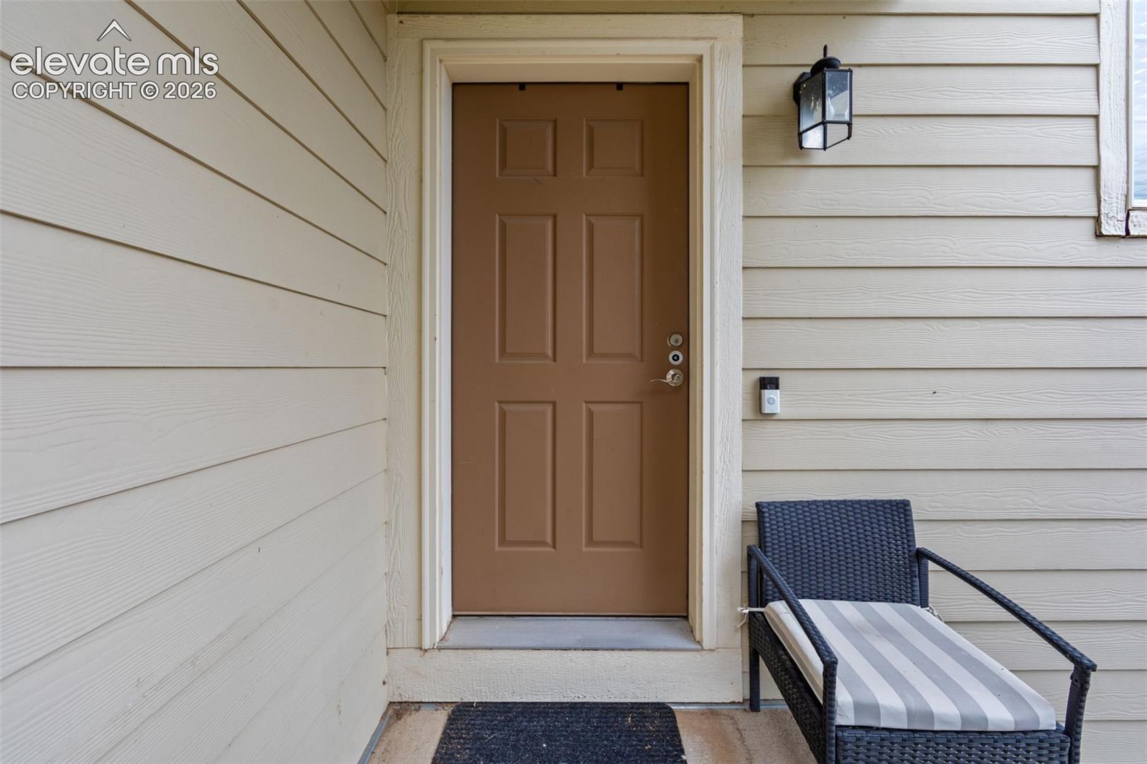 Panel-style entry door with a multi-pane exterior light fixture