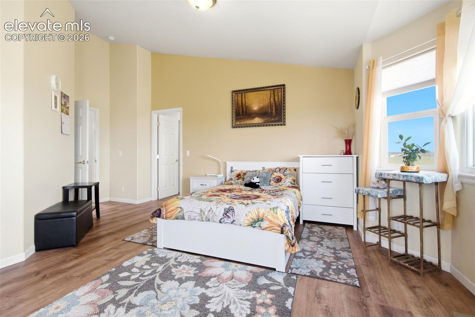 Bright, sun-filled primary bedroom featuring glass sliding door access to balcony, and ample natural light throughout