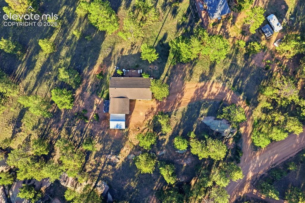 Property with a main residence, an auxiliary structure, and surrounding mature trees