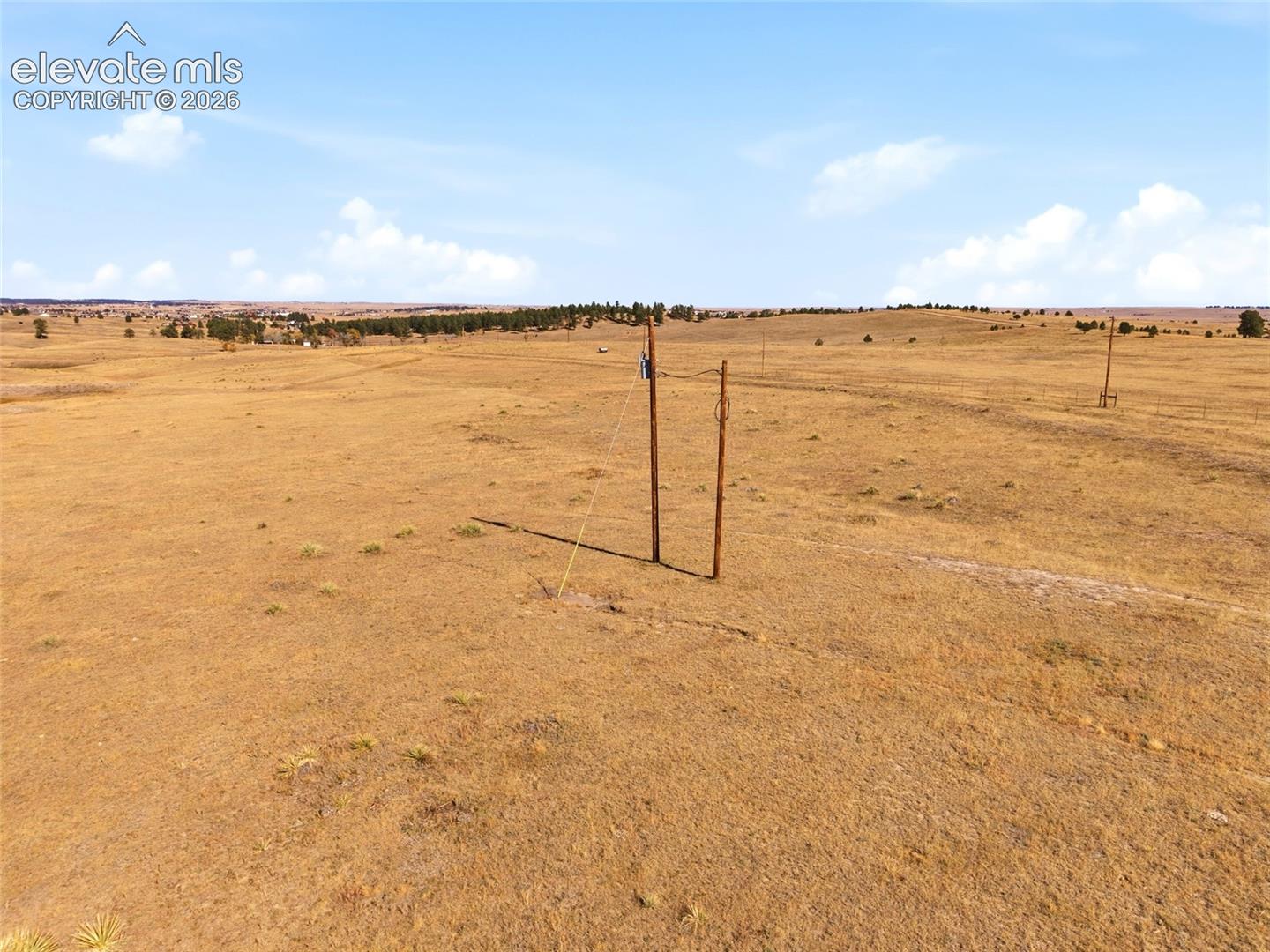 Expansive, open acreage featuring natural grasslands and utility poles