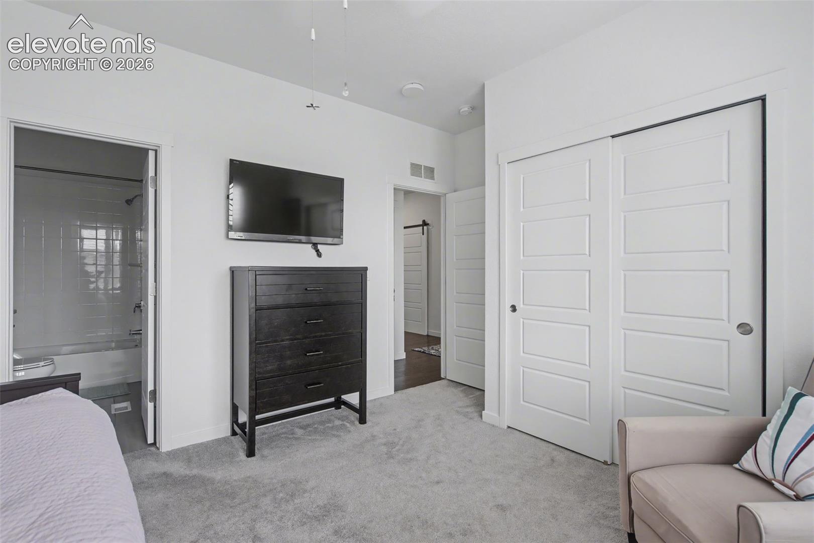 Bedroom featuring light carpet and a closet