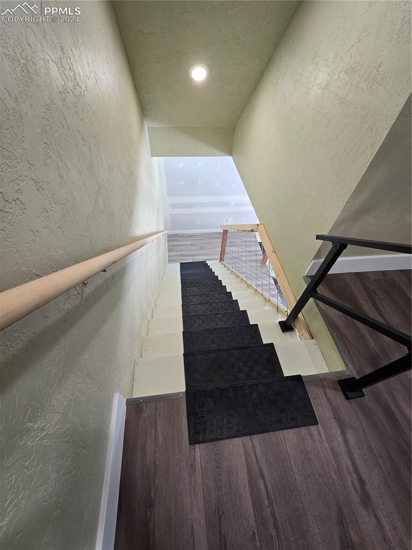 Stairway featuring hardwood / wood-style flooring