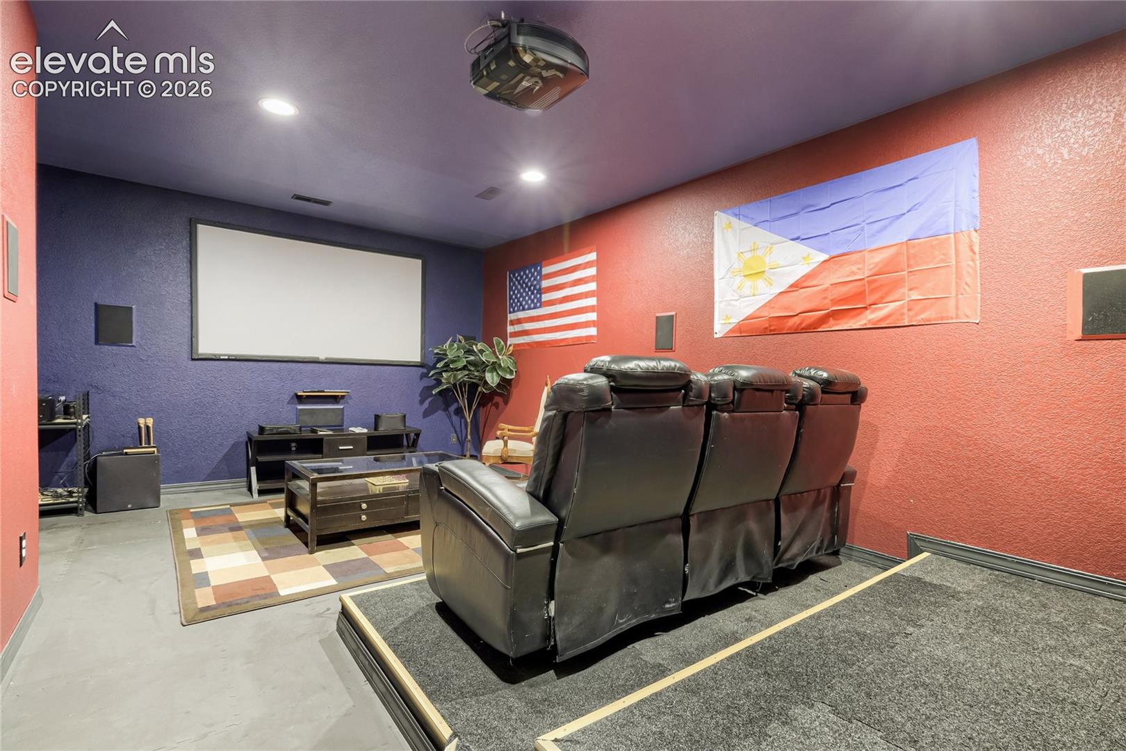 Dedicated media room featuring a large projection screen, recessed lighting, and dark-toned walls. Theater seating and all AV equipment stays!