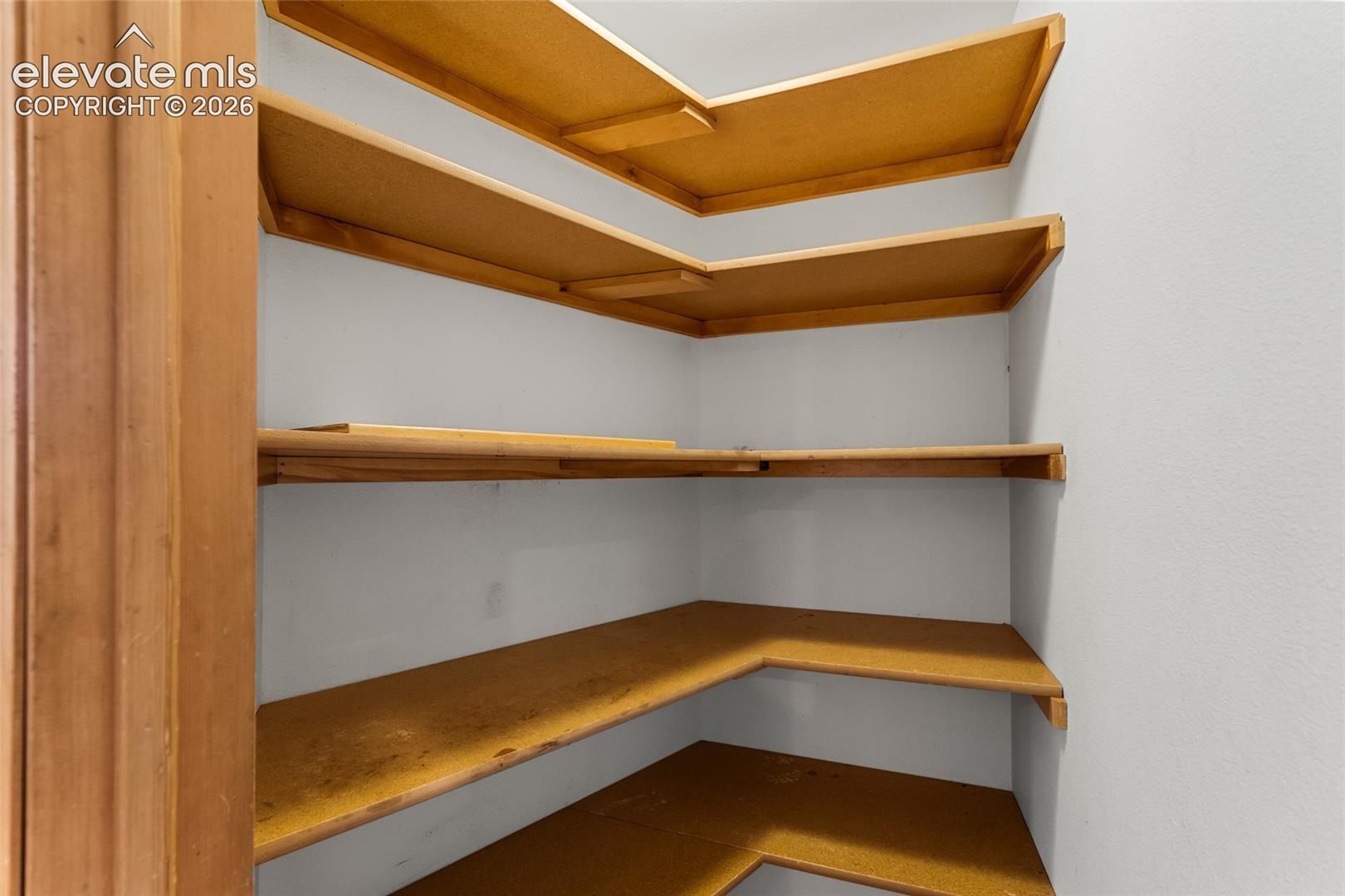Built-in shelving units with light wood-finish and white painted walls