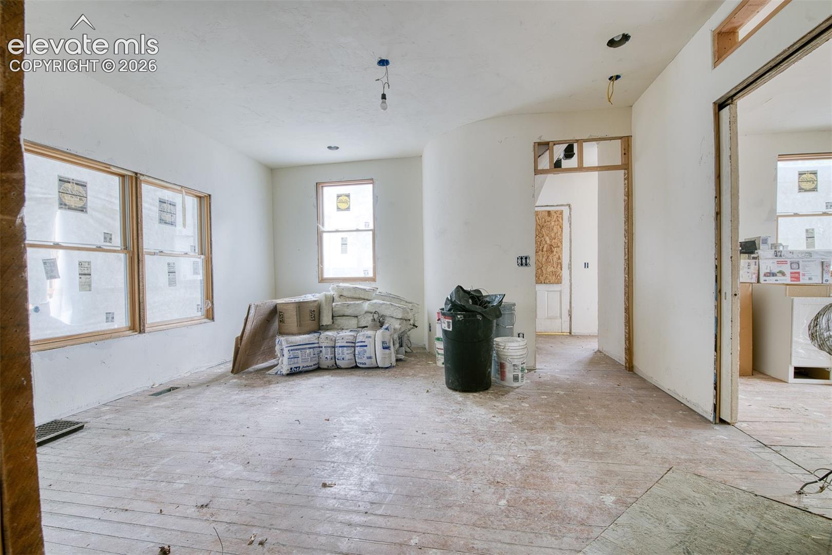 Opposite view of living room into foyer. Primary bedroom has the original pocket door and is located to the right. 