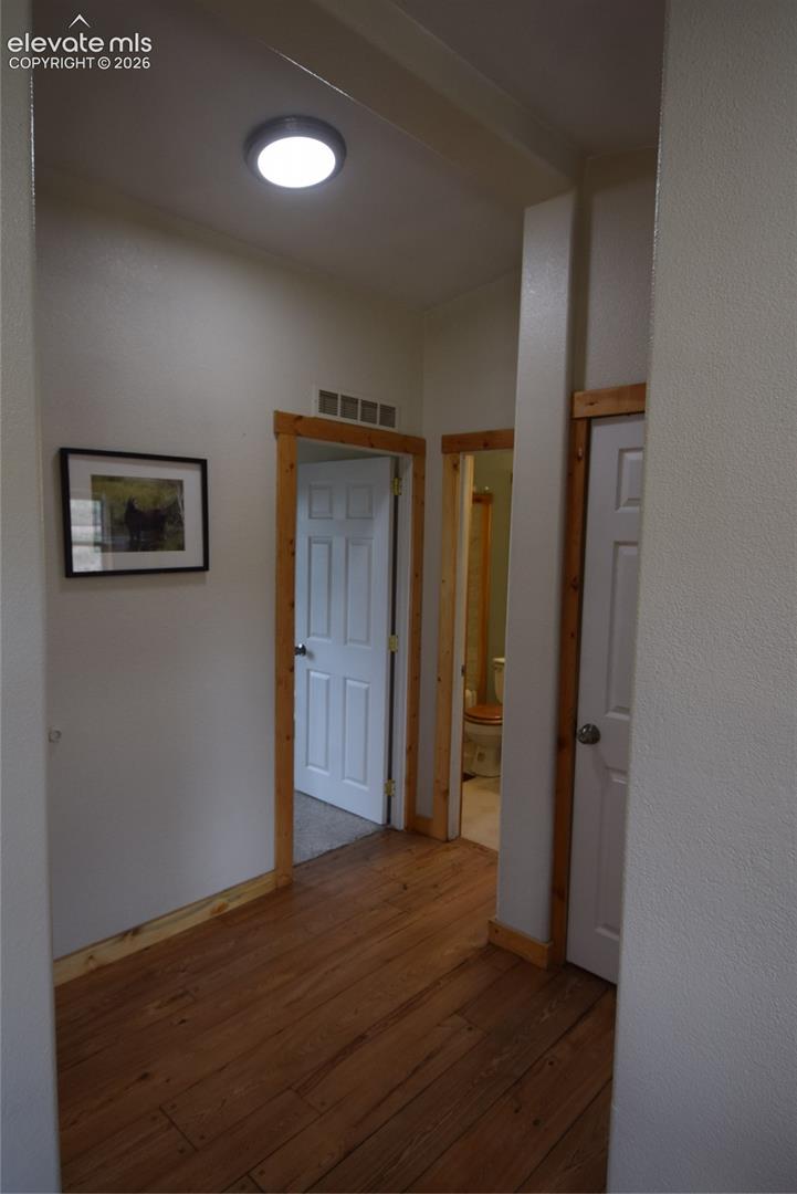 Wood-finish flooring with natural wood trim and white paneled doors