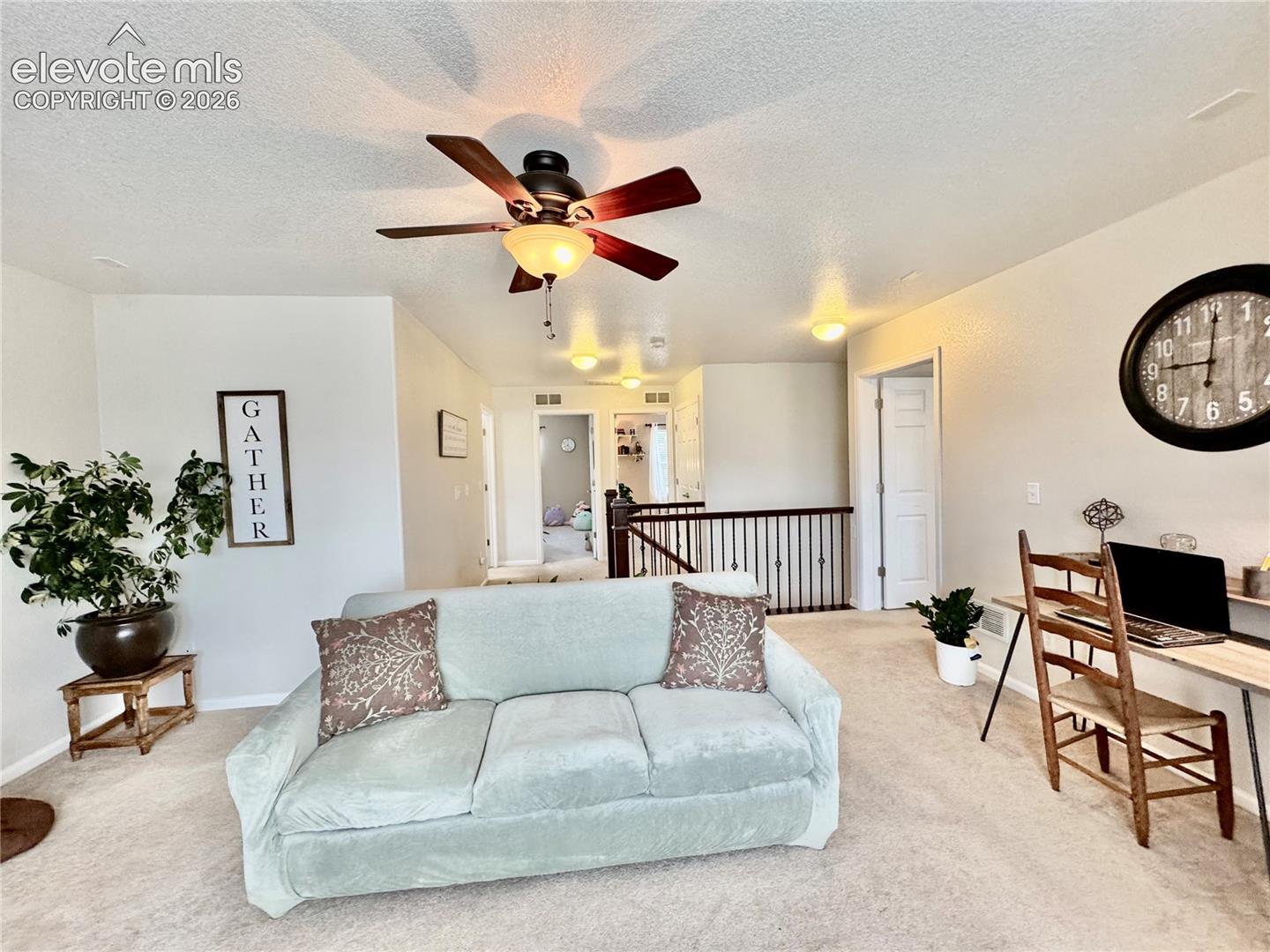 Open loft space featuring carpet flooring and neutral wall tones