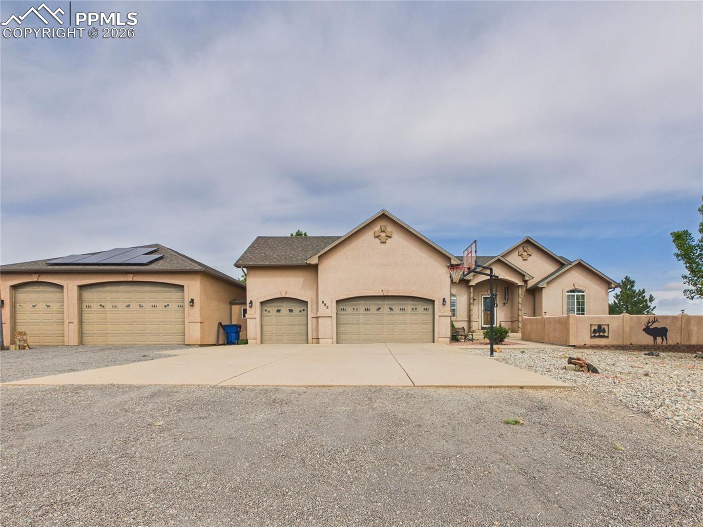 Experience luxury living in this spacious 5-bedroom, 3-bathroom home, enhanced by the energy efficiency of paid-off solar and an impressive 6-car garage/workshop combo. The main level features an open-concept, split-bedroom design with tall vaulted ceilings, elegant hardwood flooring, and a cozy gas fireplace, anchored by a chef's dream kitchen boasting abundant counter space, cabinetry, and stainless steel appliances. Retreat to the primary suite, which offers a walk-in closet and a luxurious 5-piece bathroom complete with a walk-in tub, large walk-in shower, and dual vanity. The fully finished basement, accented with tile, adds valuable living space with two additional bedrooms (one ideally suited as an office or flex space), a bathroom, and a spacious living room—perfect for guests, multi-generational living, or work-from-home flexibility. Car enthusiasts and hobbyists will appreciate the 3-car attached garage and the connected 3-car extended garage/workshop, featuring taller rafters. Outdoor amenities provide the perfect setting for entertaining and relaxation, including a fenced backyard with mature trees, green grass, a stone patio, and a pergola, while the front yard features a dining patio framed by stucco half walls.