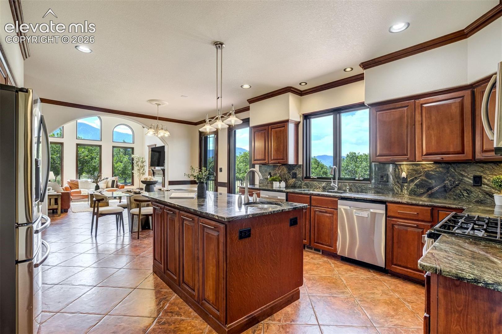 Island with a prep sink & stone counters inspired by the scenery. 