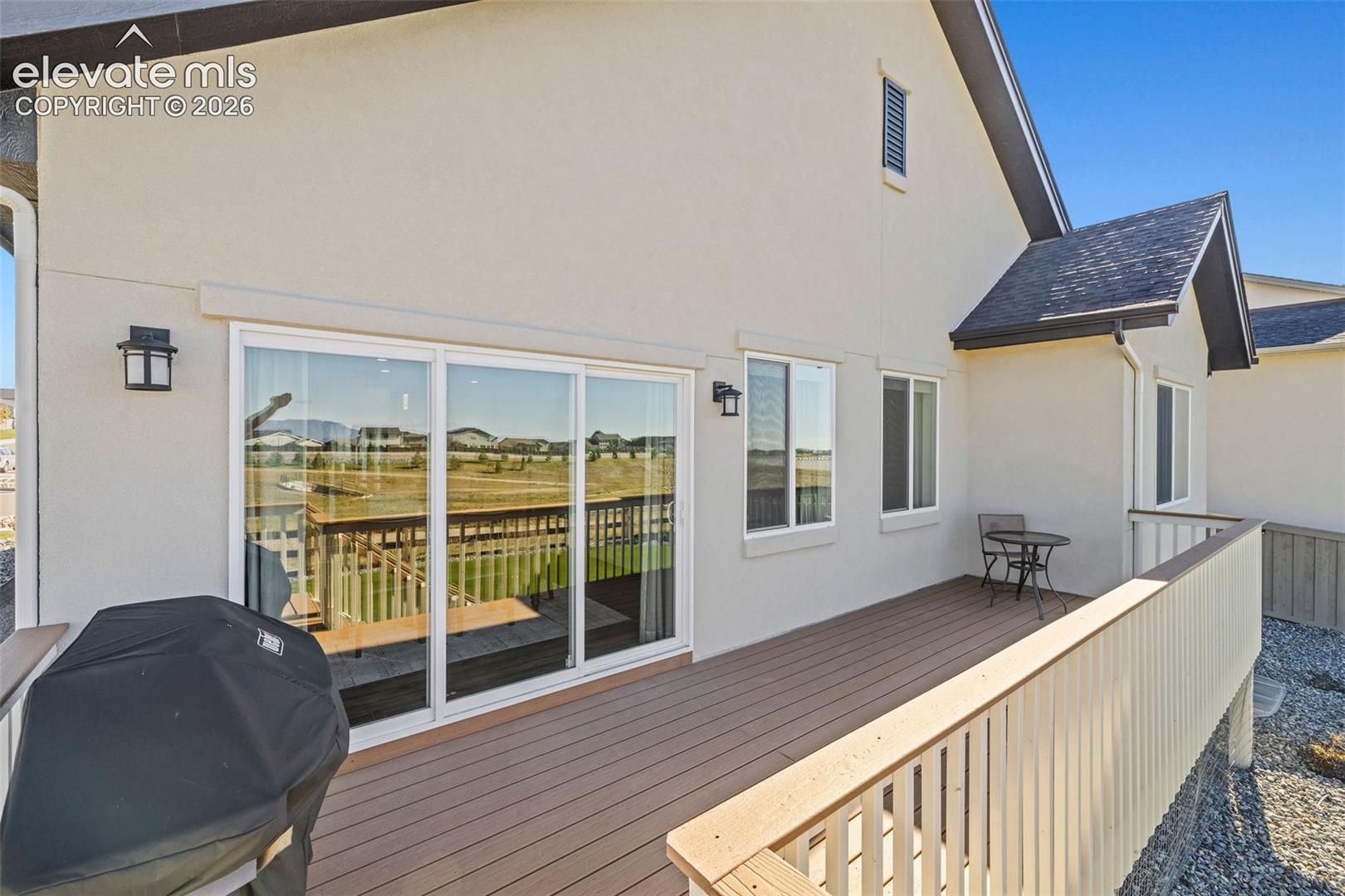 The composite deck has stairs down to the back yard and easy access to the kitchen and dining areas through the sliding glass door. 
