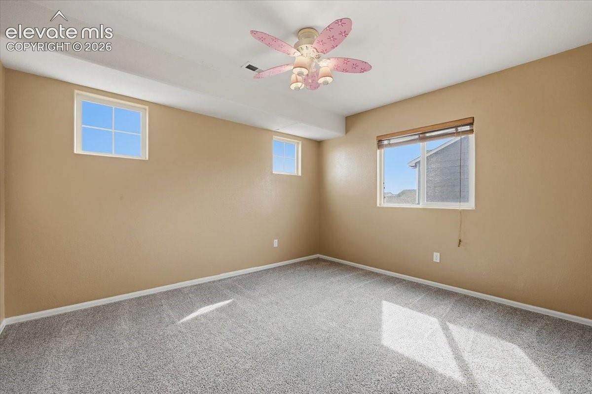 Carpeted flooring, multiple windows, ceiling fan with integrated lighting, recessed lighting, and neutral wall tones
